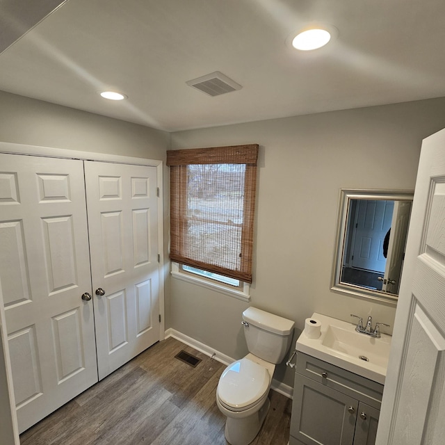 bathroom with toilet, hardwood / wood-style flooring, and vanity