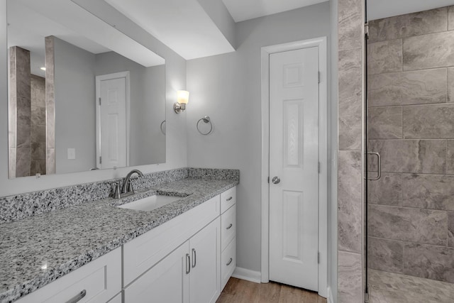 bathroom with vanity, a shower with door, and hardwood / wood-style floors