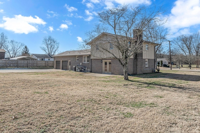 back of house featuring a garage, cooling unit, french doors, and a lawn