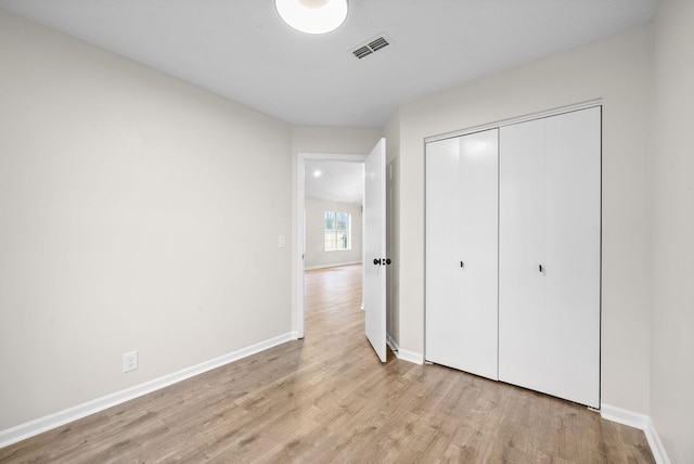 unfurnished bedroom featuring a closet and light hardwood / wood-style floors