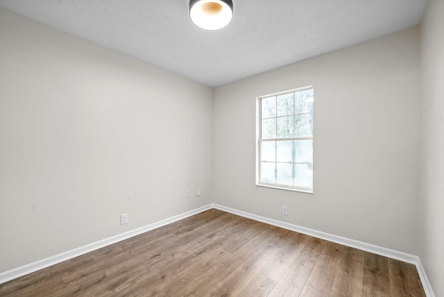 unfurnished room with hardwood / wood-style flooring