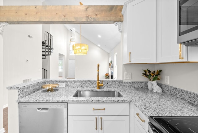 kitchen featuring vaulted ceiling, appliances with stainless steel finishes, sink, and white cabinetry