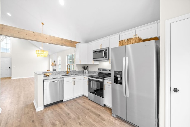 kitchen with stainless steel appliances, sink, white cabinets, and decorative light fixtures