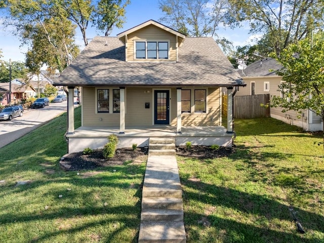 bungalow with covered porch and a front yard