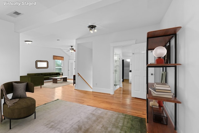 interior space with vaulted ceiling, ceiling fan, and light hardwood / wood-style floors