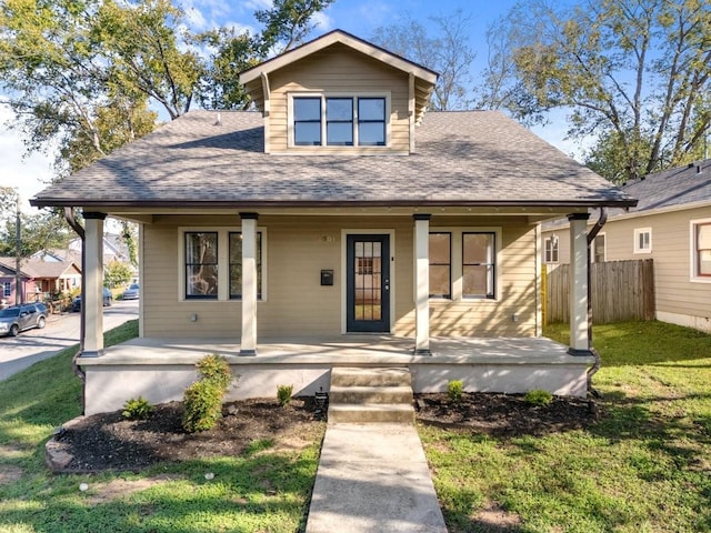 bungalow-style home with a front lawn and covered porch