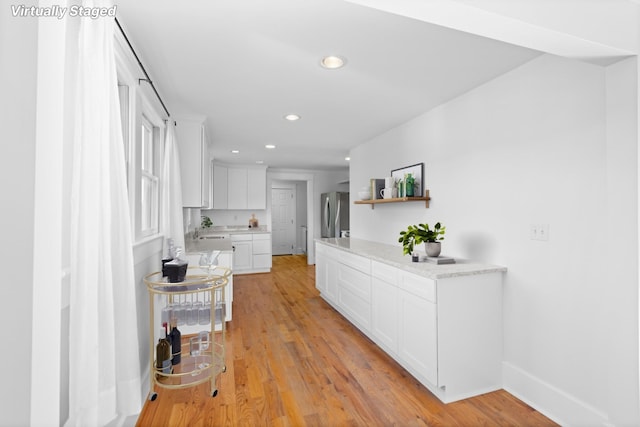 hallway featuring light hardwood / wood-style flooring and sink