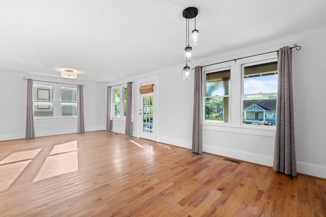 unfurnished room with a wealth of natural light and light hardwood / wood-style flooring