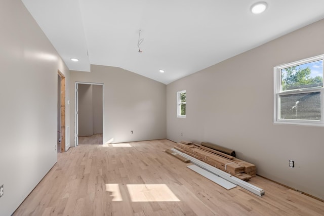 unfurnished room with light wood-type flooring and vaulted ceiling