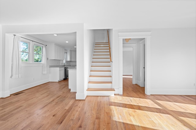 stairway featuring sink and wood-type flooring