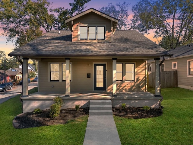 view of front of home featuring covered porch and a yard