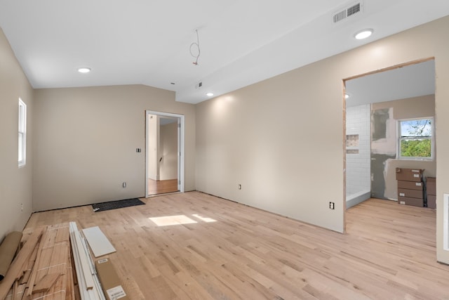 unfurnished bedroom featuring lofted ceiling and light hardwood / wood-style flooring