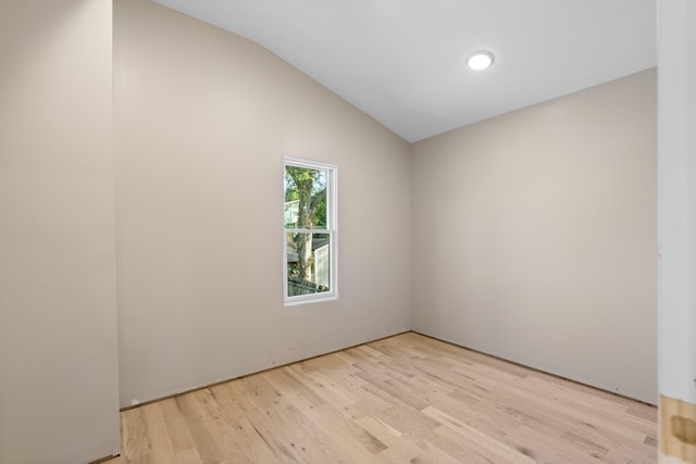 empty room with lofted ceiling and light hardwood / wood-style flooring