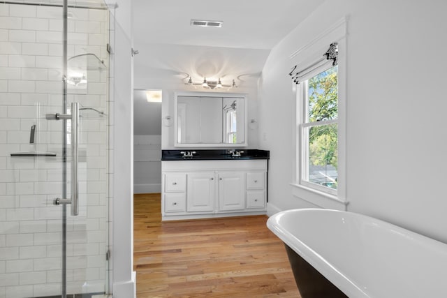 bathroom featuring a healthy amount of sunlight, independent shower and bath, vanity, and hardwood / wood-style floors