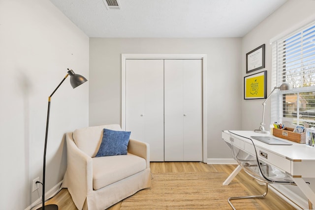 office area featuring a textured ceiling and light hardwood / wood-style floors