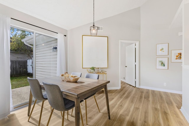 dining space featuring vaulted ceiling and light hardwood / wood-style flooring