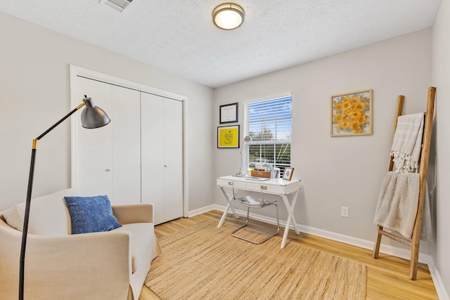 office area with a textured ceiling and hardwood / wood-style floors