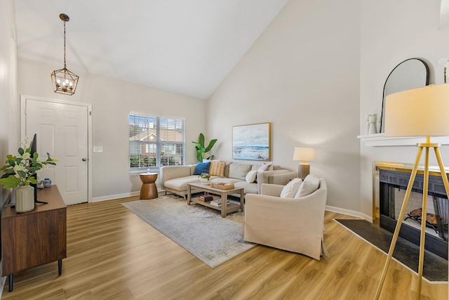 living room with high vaulted ceiling, hardwood / wood-style floors, and a notable chandelier