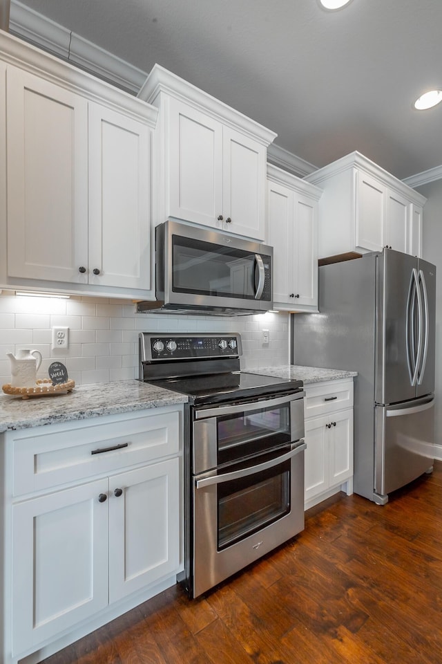 kitchen featuring backsplash, white cabinetry, stainless steel appliances, dark hardwood / wood-style flooring, and light stone counters