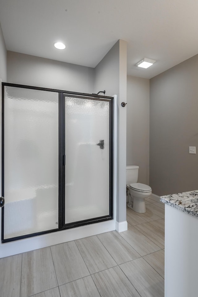 bathroom featuring toilet, walk in shower, and vanity