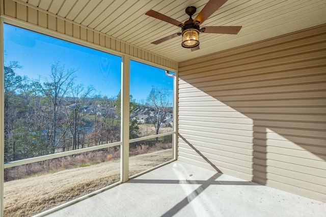 unfurnished sunroom featuring ceiling fan