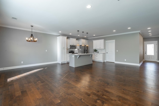 kitchen featuring white cabinetry, pendant lighting, appliances with stainless steel finishes, and a kitchen island