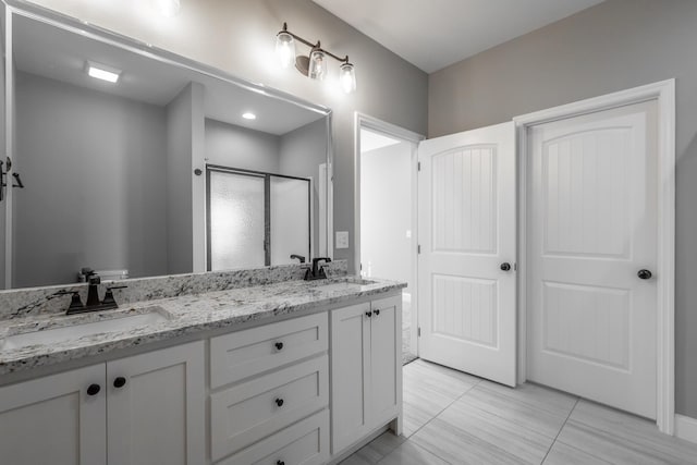 bathroom with walk in shower, vanity, and tile patterned floors