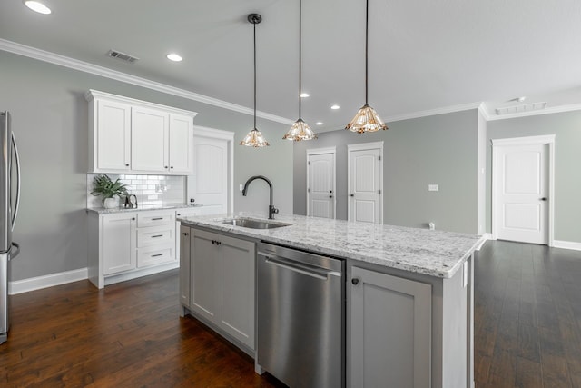 kitchen with white cabinetry, sink, hanging light fixtures, a kitchen island with sink, and crown molding