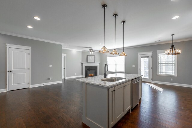 kitchen with dishwasher, sink, hanging light fixtures, light stone countertops, and ornamental molding