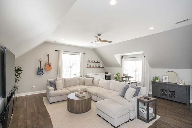 living room with dark wood-type flooring, bar area, lofted ceiling, and a healthy amount of sunlight