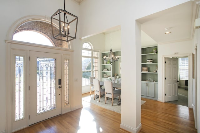 entrance foyer with hardwood / wood-style floors and a notable chandelier