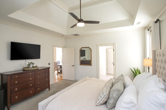 bedroom featuring ceiling fan, light colored carpet, and a tray ceiling