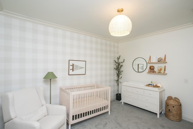 carpeted bedroom featuring a nursery area and ornamental molding