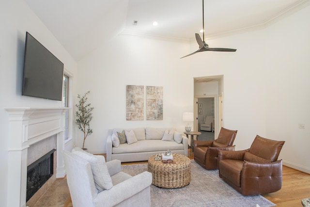 living room with ceiling fan, ornamental molding, and light hardwood / wood-style flooring