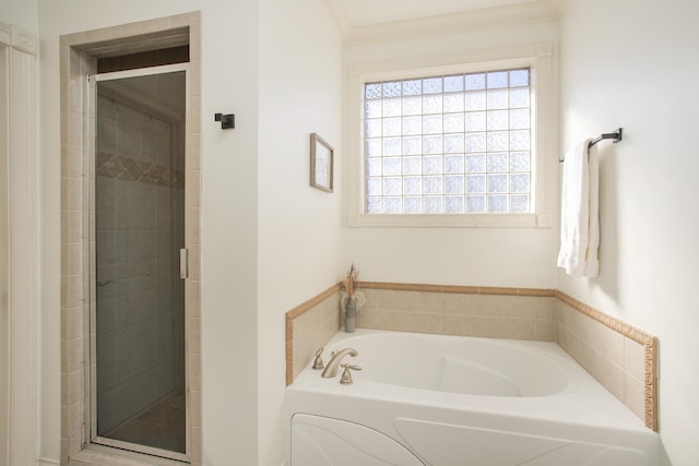 bathroom with ornamental molding and shower with separate bathtub