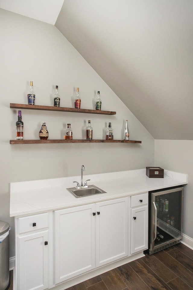 bar with sink, white cabinetry, lofted ceiling, and wine cooler