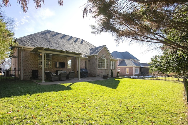 back of property with an outdoor living space with a fireplace, a patio area, and a yard