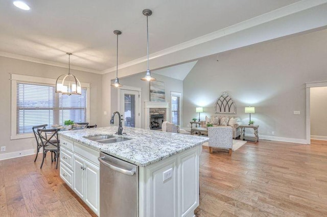 kitchen featuring dishwasher, a center island with sink, sink, hanging light fixtures, and white cabinets