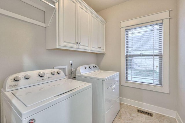 laundry area with washer and clothes dryer and cabinets