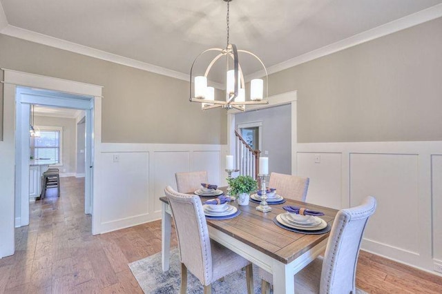 dining room featuring ornamental molding, a chandelier, and light wood-type flooring