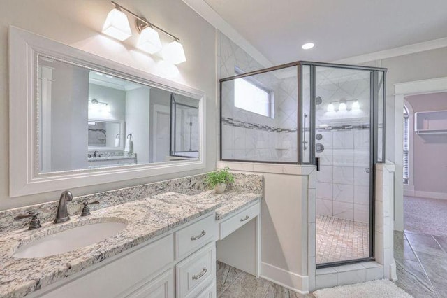 bathroom featuring an enclosed shower, vanity, and ornamental molding