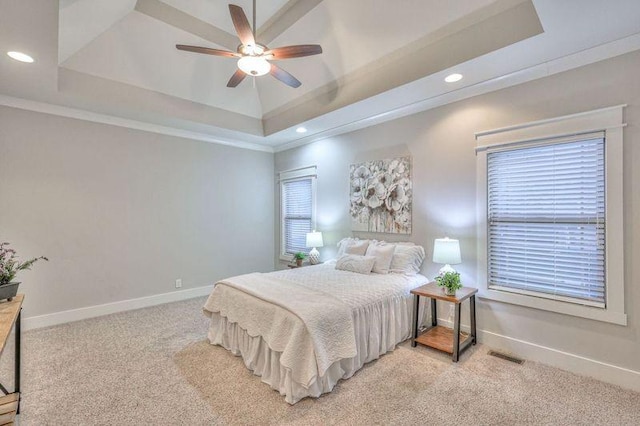 carpeted bedroom featuring a raised ceiling, ceiling fan, and crown molding