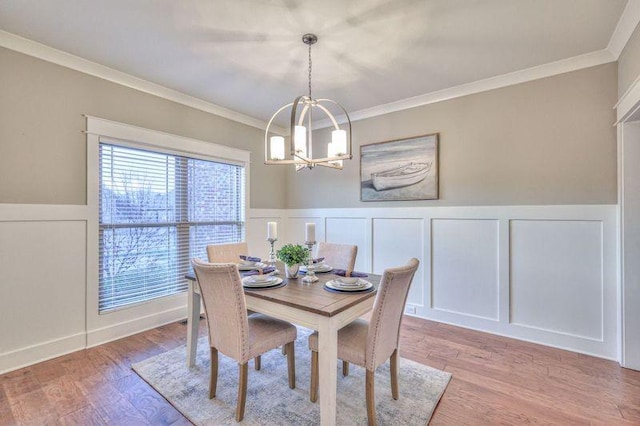 dining area featuring light hardwood / wood-style flooring, crown molding, and an inviting chandelier