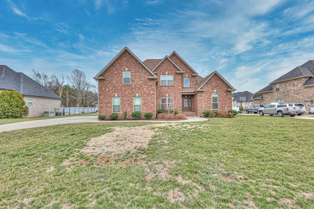 traditional-style home featuring a front lawn and brick siding