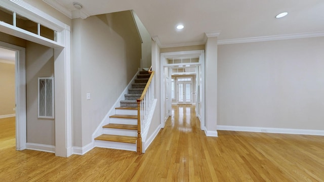 stairs featuring ornamental molding and hardwood / wood-style floors