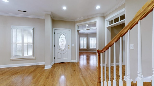 foyer entrance featuring ornamental molding and light hardwood / wood-style floors