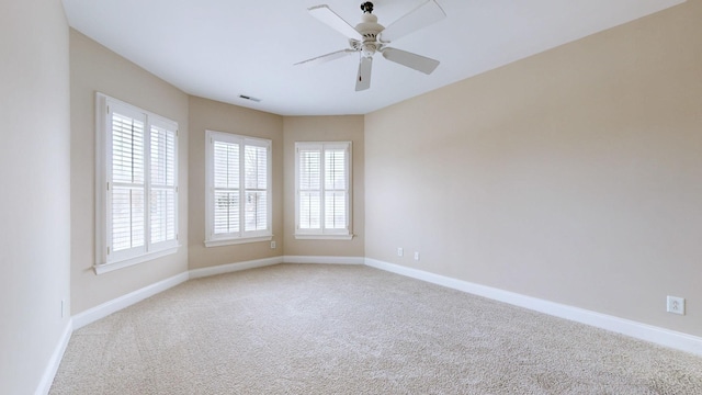 carpeted empty room featuring plenty of natural light and ceiling fan