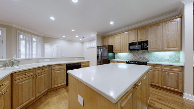 kitchen with sink, light hardwood / wood-style flooring, backsplash, a center island, and black appliances