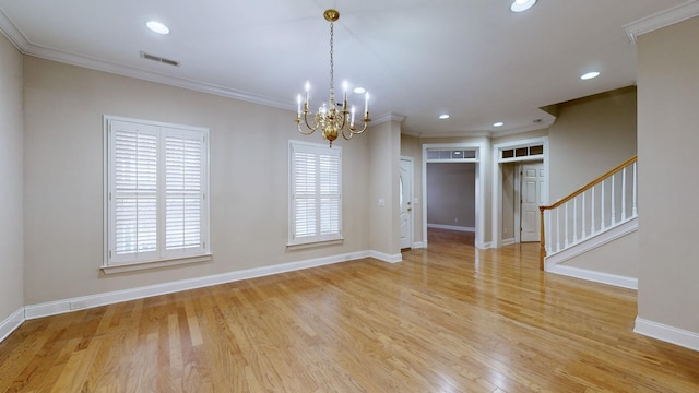 empty room with crown molding, a chandelier, and light wood-type flooring