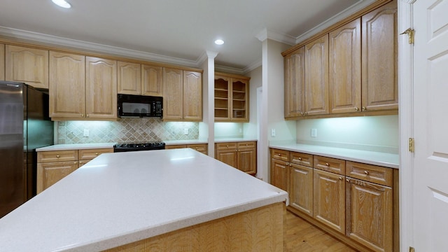 kitchen featuring tasteful backsplash, crown molding, light hardwood / wood-style floors, and black appliances